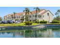 Well-maintained building exterior with lush landscaping, palm trees, pond and parking at 6131 Bahia Del Mar Blvd # 240, St Petersburg, FL 33715