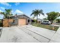 Single-story home with attached garage, manicured landscaping, and a long driveway, offering curb appeal at 6821 Tierra Verde St, Port Richey, FL 34668