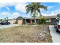 Charming single-story home featuring a well-kept front yard with mature landscaping and a spacious driveway at 6821 Tierra Verde St, Port Richey, FL 34668