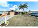 Charming single-story home featuring a well-kept front yard with mature landscaping and a spacious driveway at 6821 Tierra Verde St, Port Richey, FL 34668