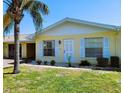 A bright and airy home exterior featuring a sunny facade, manicured lawn and carport on a clear day at 1012 Warwick Ct, Sun City Center, FL 33573