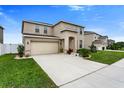 Two-story home featuring a two-car garage and landscaped front yard at 12017 Grand Kempston Dr, Gibsonton, FL 33534