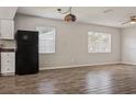 Open-concept living area with wood-look floors, natural light, and kitchen access at 14013 Briardale Ln, Tampa, FL 33618