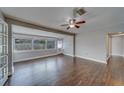 A bright living room features new wood floors, fresh neutral paint, and large windows at 1536 Alamo Ln, Dunedin, FL 34698