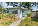 A charming single-story home with a blue front door and well-maintained landscaping at 1821 20Th N Ave, St Petersburg, FL 33713