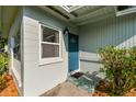 Close-up of a home's inviting blue front door with a decorative window and a stylish exterior light fixture at 1821 20Th N Ave, St Petersburg, FL 33713