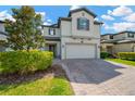 Beautiful two-story home featuring manicured landscaping and a brick paved driveway leading to a two car garage at 19592 Breynia Dr, Lutz, FL 33558