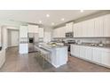 Spacious kitchen with white cabinets, stainless steel appliances, granite countertops and large kitchen island at 19681 Gladeview Way, Land O Lakes, FL 34638