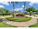 Well-manicured front yard with circular driveway, lush landscaping and mature trees at 2216 El De Oro Dr, Clearwater, FL 33764