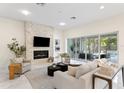 Bright living room features a stone fireplace, modern furniture, and seamless indoor-outdoor living at 3411 W El Prado Blvd, Tampa, FL 33629