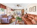 Inviting living room with hardwood floors, ceiling fan, comfortable seating, and sliding glass doors to the lanai at 4022 Lighthouse Way, New Port Richey, FL 34652