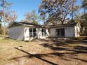 Back exterior of home featuring multiple windows and a sliding glass door at 4405 Coconut Cove Pl, Valrico, FL 33596