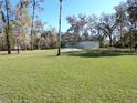 Wide shot of the home, emphasizing its large backyard with mature trees at 4405 Coconut Cove Pl, Valrico, FL 33596