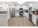 Bright kitchen featuring white cabinets, stainless steel appliances, and granite countertops, with modern updates at 715 Charlotte Ave, Tarpon Springs, FL 34689