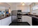 Efficient kitchen featuring stainless steel appliances and ample cabinet space with view to adjacent living area at 750 Burlington N Ave # 4L, St Petersburg, FL 33701