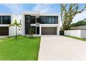 Modern two-story home with minimalist landscaping, a grey two-car garage, and sleek architectural design at 7608 Antilla St, Tampa, FL 33625