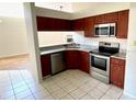 Open kitchen featuring stainless steel appliances, granite countertops, and tiled floors at 8608 Twin Farms Pl, Tampa, FL 33635
