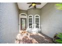 Covered entryway features decorative brick flooring and double windows showcasing the architecture at 12929 Royal George Ave, Odessa, FL 33556