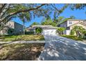 Traditional home with a large driveway, mature trees and well-manicured lawn at 12929 Royal George Ave, Odessa, FL 33556