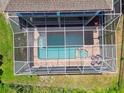 Aerial view looking into screened pool area with spa and furniture at 13310 Waterford Run Dr, Riverview, FL 33569