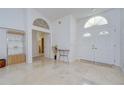 Inviting foyer featuring double doors, marble floors, and decorative shelving at 14119 Stonegate Dr, Tampa, FL 33624