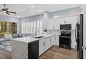 Open-concept kitchen with a large island, white cabinetry, stainless steel appliances, and views of the adjacent living area at 14521 Mirasol Manor Ct, Tampa, FL 33626