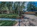 Paver driveway leading to a 2-car garage with lush front yard and tropical landscaping at 20 Willowwood Ln, Oldsmar, FL 34677