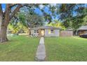 Lovely single-story home with a well-manicured lawn and a quaint walkway at 2001 E Idlewild Ave, Tampa, FL 33610