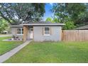 Cozy single-story home with decorative wood shutters and a lush green lawn at 2001 E Idlewild Ave, Tampa, FL 33610