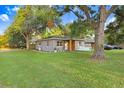 Landscaped front yard featuring mature trees and a freshly painted home exterior at 2001 E Idlewild Ave, Tampa, FL 33610