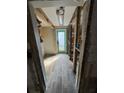 Hallway under construction with new flooring leading to an inviting, light blue back door for a fresh start at 204 162Nd Ave, Redington Beach, FL 33708