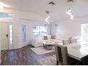 Bright open-plan living room features modern lighting, wood-look flooring, and neutral decor at 25417 Lexington Oaks Blvd, Wesley Chapel, FL 33544