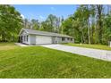 Exterior view of this home featuring an attached garage and long concrete driveway at 346 Ranch Rd, Tarpon Springs, FL 34688