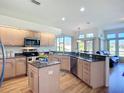 Well-lit kitchen featuring granite countertops, stainless steel appliances, and a view to the sunroom at 3625 Gaviota Dr, Ruskin, FL 33573