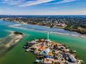 Aerial view of a waterfront home with a pool and dock on a canal leading to the Gulf of Mexico at 366 La Hacienda Dr, Indian Rocks Beach, FL 33785