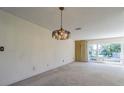 Bright living room with an ornate chandelier and large windows at 601 Riviera Bay Ne Dr, St Petersburg, FL 33702