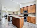 A cozy kitchen with stainless steel appliances, wooden cabinets, and a convenient center island at 6812 Guilford Bridge Dr, Apollo Beach, FL 33572