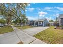 View of the side of the home showing the long driveway, sidewalk, and street at 940 57Th N Ave, St Petersburg, FL 33703