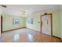 Bright living room with hardwood floors, a ceiling fan, and natural light from two windows at 940 57Th N Ave, St Petersburg, FL 33703