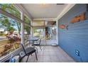 Enclosed porch with tiled floor and casual seating, offering a relaxing outdoor space at 940 57Th N Ave, St Petersburg, FL 33703