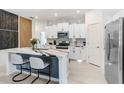 Modern kitchen with stainless steel appliances, granite countertops, and a breakfast bar with seating at 9617 Branching Ship Trce, Wesley Chapel, FL 33545