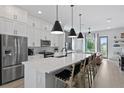 Open-concept kitchen featuring white cabinets, a large island and stainless steel appliances at 98 29Th S St, St Petersburg, FL 33712