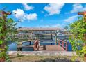 Waterfront home featuring a private boat dock and lift on a serene canal with lush greenery and sunny skies at 1012 Spindle Palm Way, Apollo Beach, FL 33572
