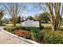 Entrance sign for Grand Olde Carrollwood surrounded by manicured landscaping and mature trees at 10316 Carrollwood Ct # 57, Tampa, FL 33618