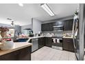 Well-lit kitchen featuring dark cabinetry, modern stainless steel appliances, and ample counter space at 10849 Kensington Park Ave, Riverview, FL 33578