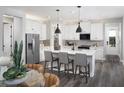 Modern kitchen with white cabinets, a central island with bar seating, and stainless steel appliances at 11288 Boundless Ter, Venice, FL 34293