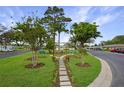 Inviting community green space with benches, walking path, landscaping, and mature trees at 11728 Carissa Ln # 0, New Port Richey, FL 34654