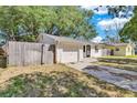 Cozy house featuring a neat front yard, driveway, and attached garage, complemented by a wooden fence at 129 Nw Lincoln N Cir, St Petersburg, FL 33702