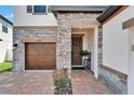 Inviting front door with a wreath and stone accents, alongside a brick driveway at 13042 Pennybrook Dr, Riverview, FL 33579