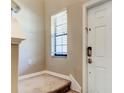 Inviting entryway with a white door, neutral walls, and carpeted stairs at 13923 Arbor Pines Dr, Riverview, FL 33579